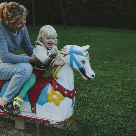 Femke met dochter Lena op een hobbelpaard